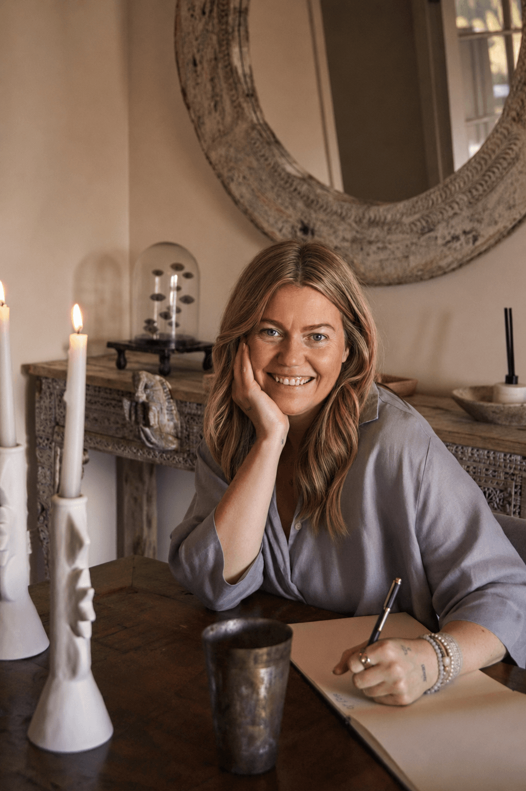 Olivia Carr at a table with a notebook, looking at the camera.